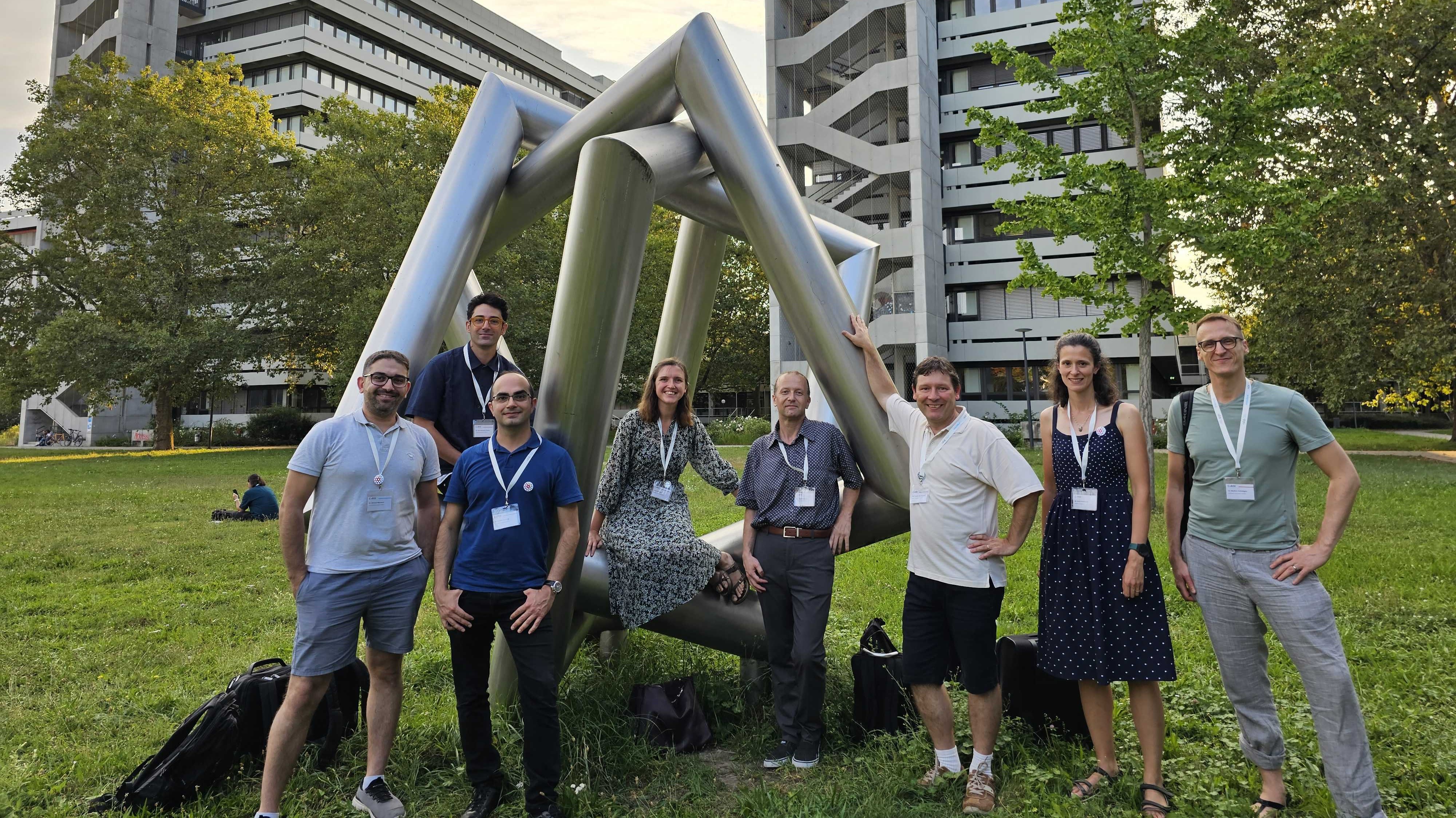 A photograph of several FAIRmat team members standing around a sculpture at the KIT.